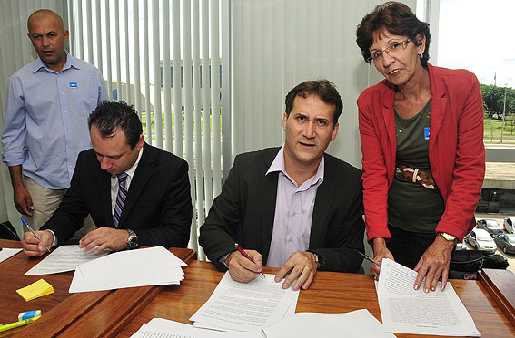 Valdir de Souza (em pé), Arlei Medeiros e Glória Nozella, dirigentes do Unificados,  participam da assinatura do documento, junto com o advogado Vinícius Cascone (2º à esq)